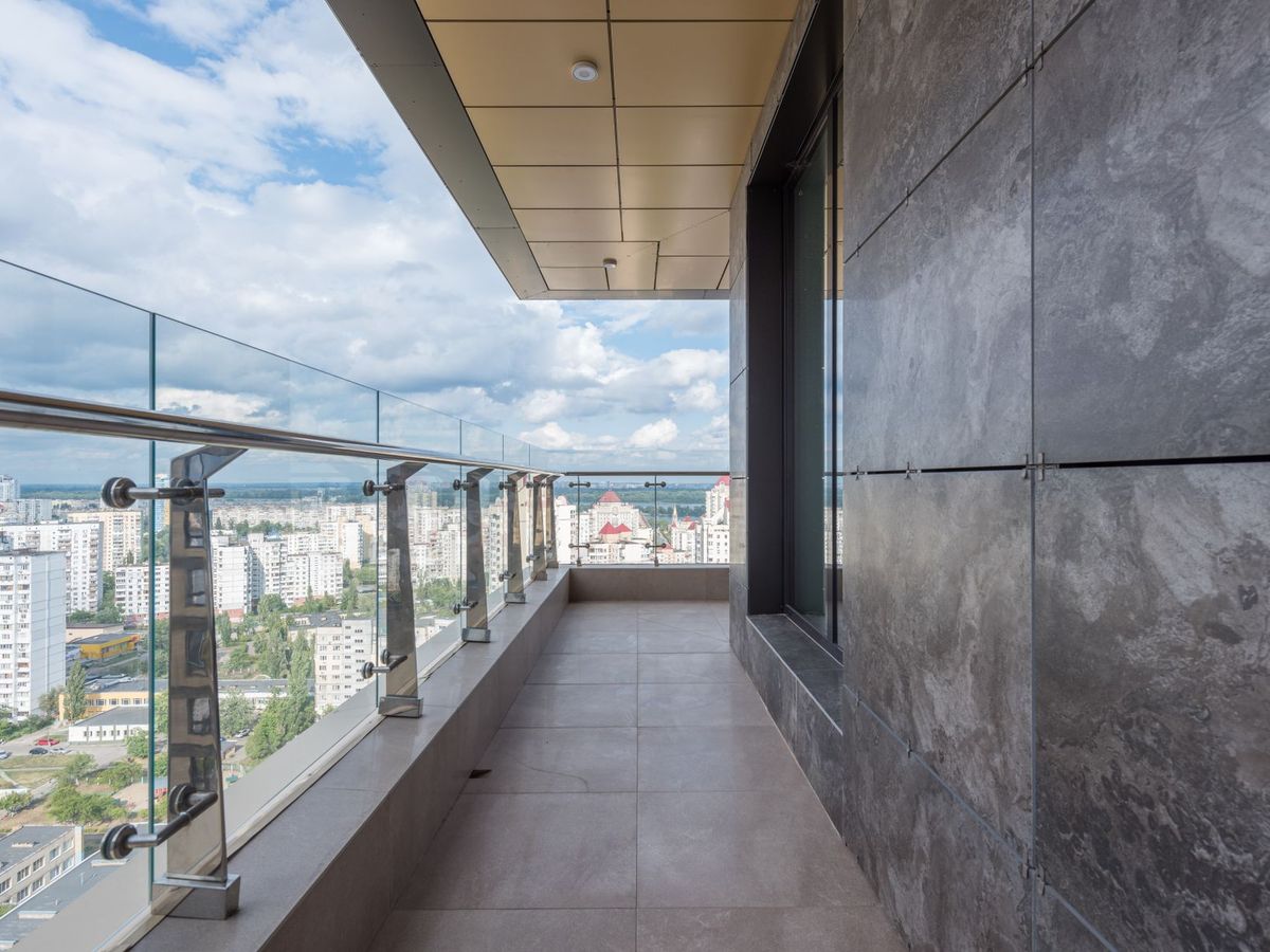 Terraza con barandilla de vidrio y pasamanos de acero