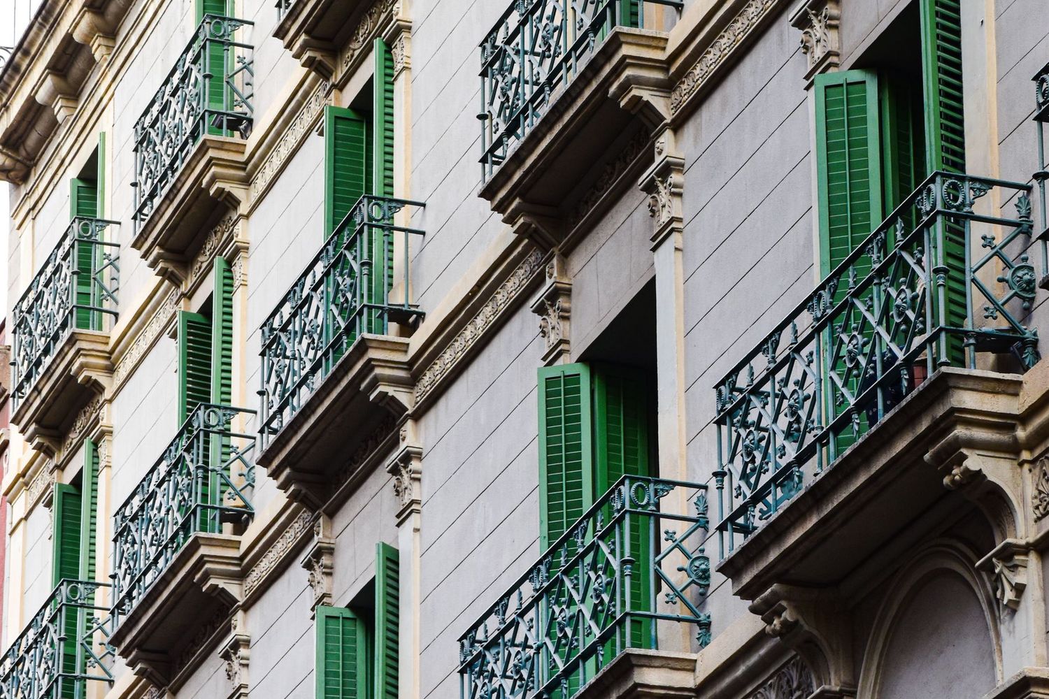 Fachada de una finca del Eixample de Barcelona con balcones y persianas